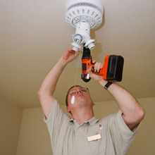 A man installing a light fixture